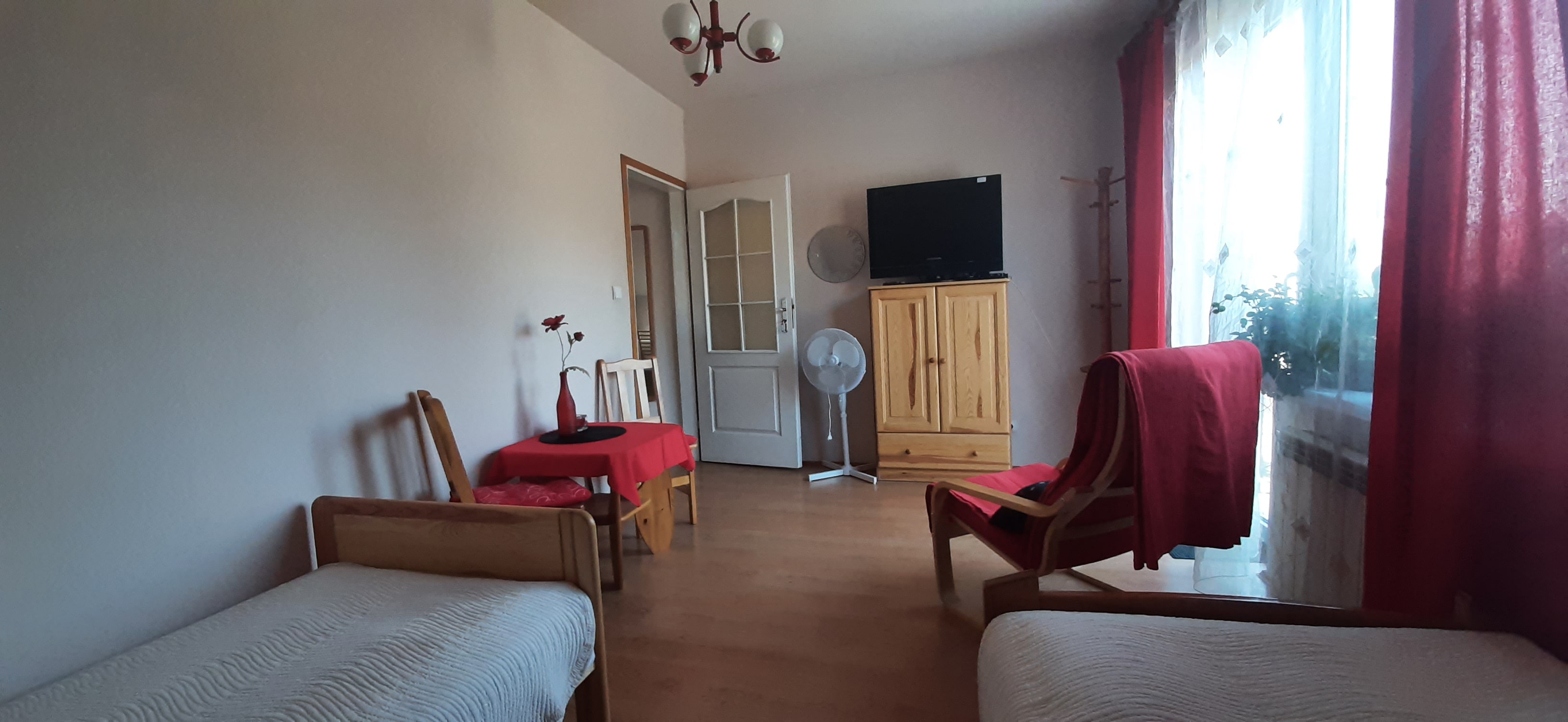 Pokój: telewizor, stół, balkon